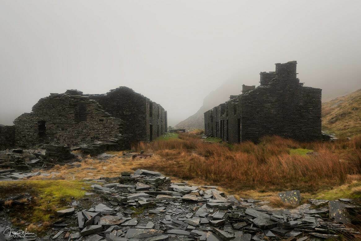 Quarry slate in the foreground with Rhosydd Barracks just beginning to get covered by mist as it rolls in through the valley.